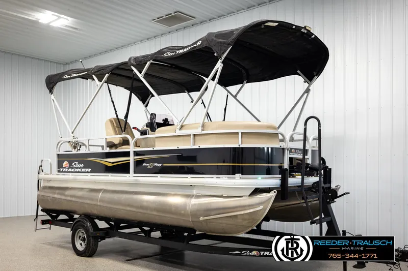 Slide: The Image of 2022 SUNTRACKER BASS BUGGY 18 DLX pontoon boat on trailer in indoor showroom. - 3