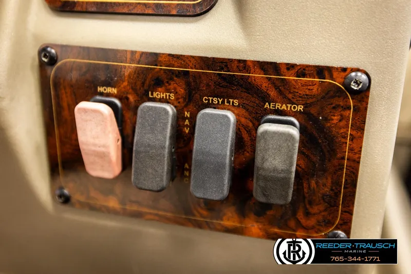 Slide: The Image of Control panel of 2022 SUNTRACKER BASS BUGGY 18 DLX with switches for horn, lights, and aerator. - 31