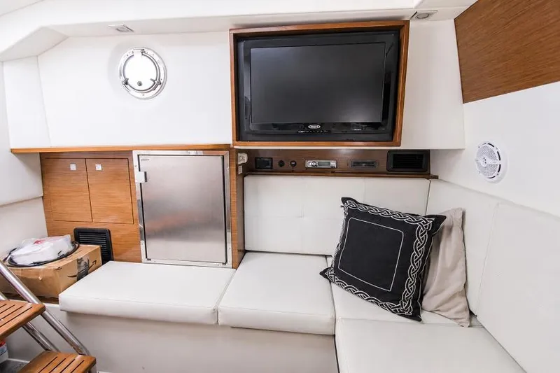 Slide: The Image of Interior of 2015 Cruisers Sport Series 328 Bow Rider with TV, seating, and storage. - 12