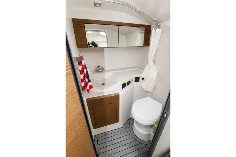 Slide: The Image of 2015 Cruisers Sport Series 328 Bow Rider bathroom with modern fixtures and wood accents. - 13