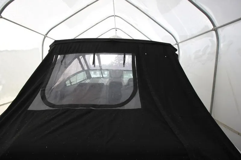 Slide: The Image of 2015 Cruisers Sport Series 328 Bow Rider under protective cover in storage. - 14