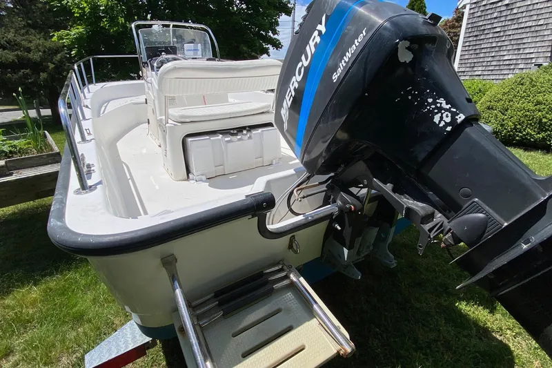 Slide: The Image of 2004 Boston Whaler 170 Montauk boat with Mercury Saltwater engine on grassy area. - 2