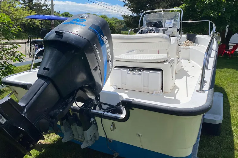 Slide: The Image of 2004 Boston Whaler 170 Montauk boat with Mercury outboard motor on grassy area. - 3