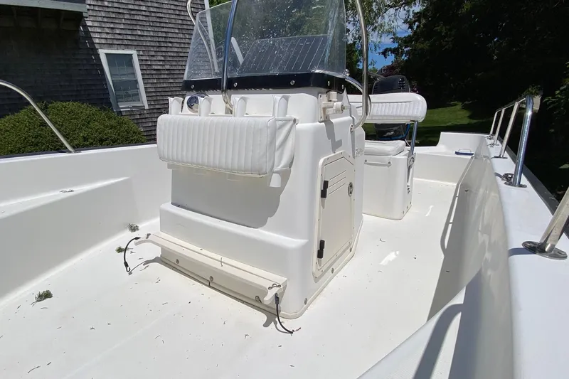 Slide: The Image of 2004 Boston Whaler 170 Montauk boat interior with console and seating, in a sunny outdoor setting. - 8