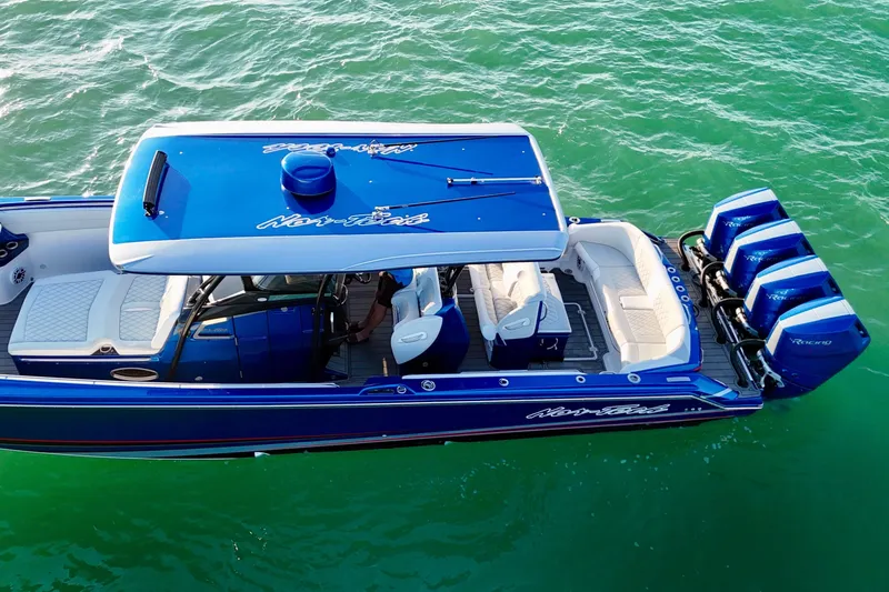 Slide: The Image of 2026 Nor-Tech 390 Sport Center Console boat on turquoise water, featuring triple engines. - 13