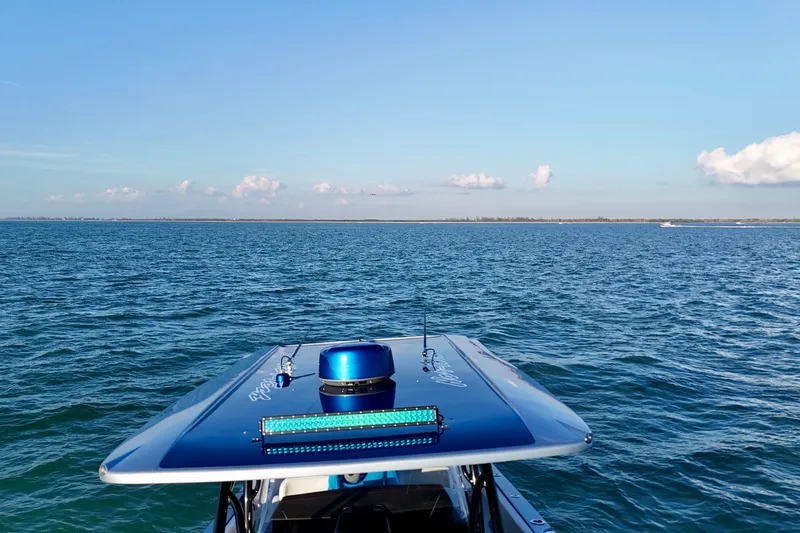 Slide: The Image of 2026 Nor-Tech 390 Sport Center Console on open water, clear sky background. - 26