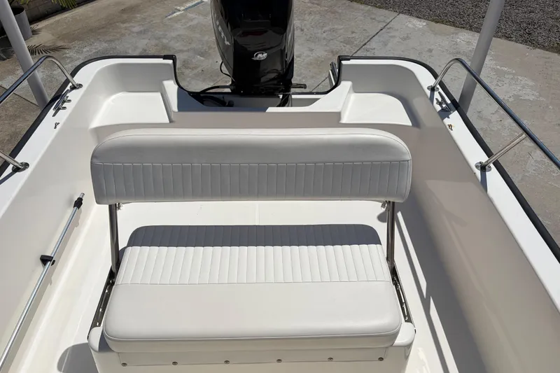 Slide: The Image of 2012 Boston Whaler 170 Montauk boat interior with white seating and motor. - 13