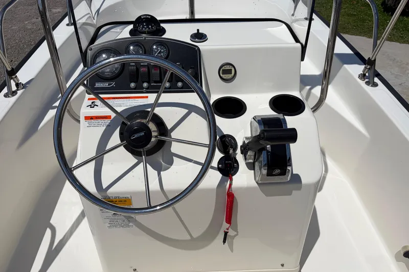 Slide: The Image of 2012 Boston Whaler 170 Montauk boat console with steering wheel and controls. - 15