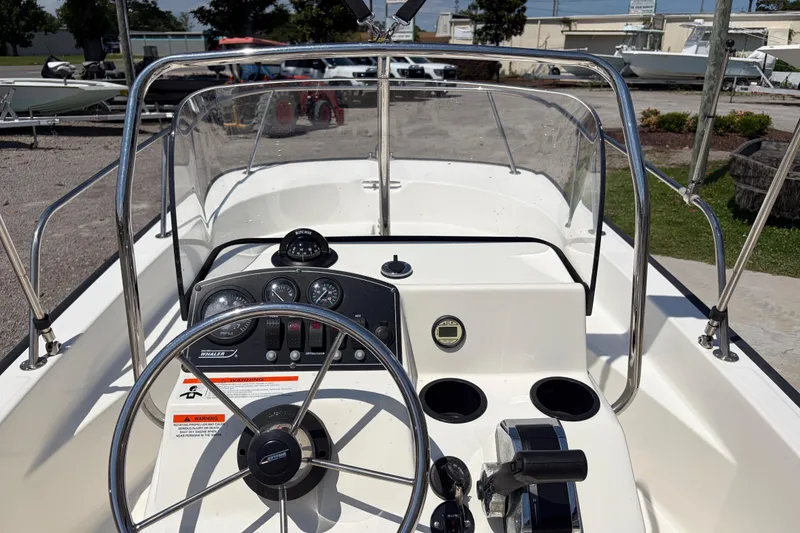 Slide: The Image of 2012 Boston Whaler 170 Montauk boat dashboard with steering wheel and controls. - 16