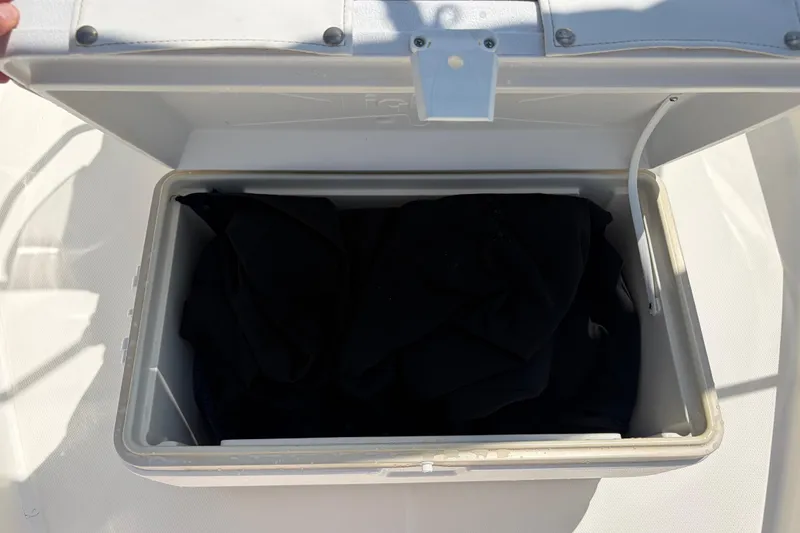 Slide: The Image of Open storage compartment on 2012 Boston Whaler 170 Montauk boat, containing dark fabric. - 20