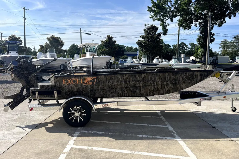 Slide: The Image of 2026 Excel 1754 Shallow Water F4 Pro Hull boat on trailer, parked outdoors. - 4
