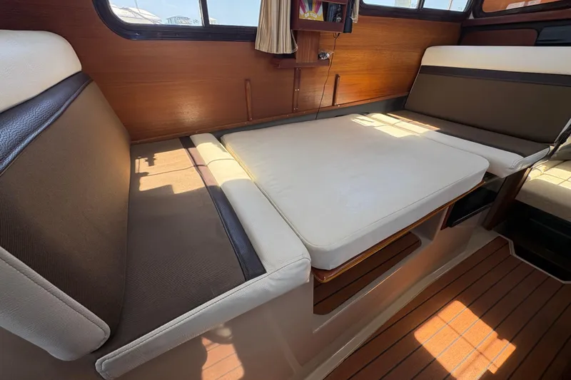 Slide: The Image of Interior of 2017 Ranger Tugs R-27 with convertible seating and wooden accents. - 20