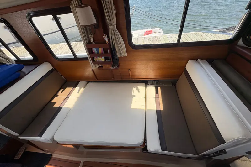 Slide: The Image of Interior of 2017 Ranger Tugs R-27 with convertible seating and waterfront view. - 19
