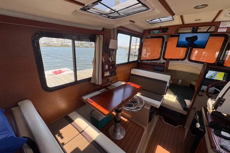 Slide: The Image of Interior of 2017 Ranger Tugs R-27 boat with dining area and windows. - 16