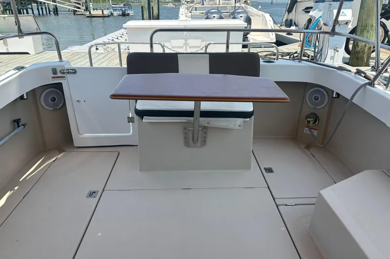 Slide: The Image of 2017 Ranger Tugs R-27 boat deck with table and seating, docked at marina. - 7