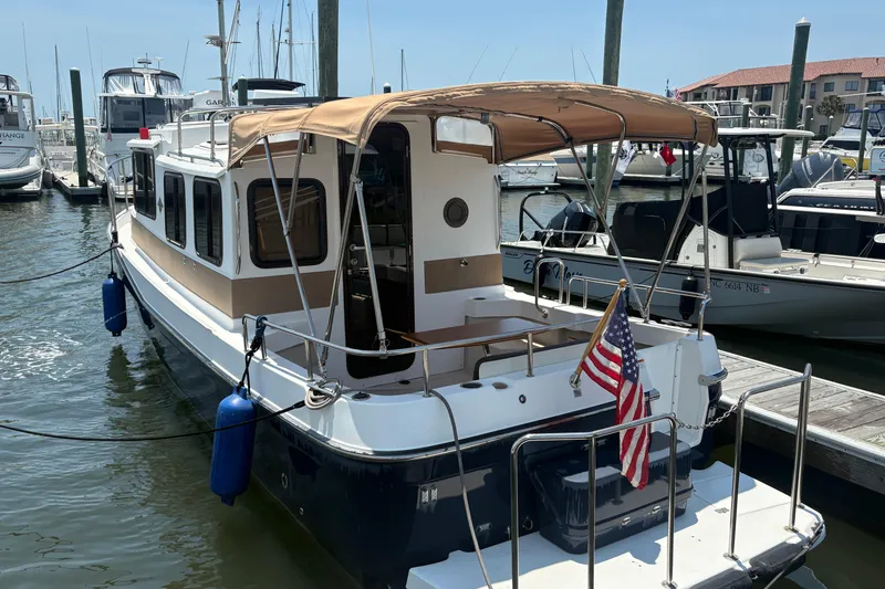 Slide: The Image of 2017 Ranger Tugs R-27 boat docked at marina with American flag. - 3