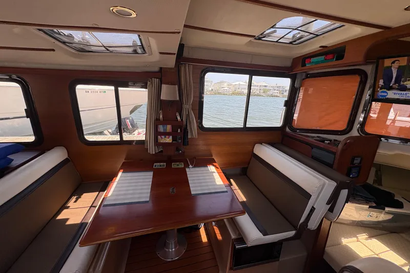 Slide: The Image of Interior of 2017 Ranger Tugs R-27 boat with dining area and waterfront view. - 18