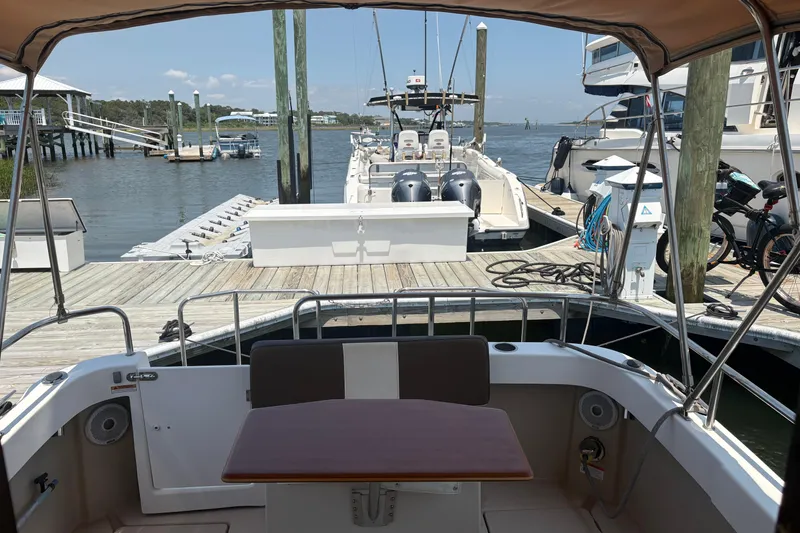 Slide: The Image of 2017 Ranger Tugs R-27 docked at a marina with scenic waterfront view. - 26