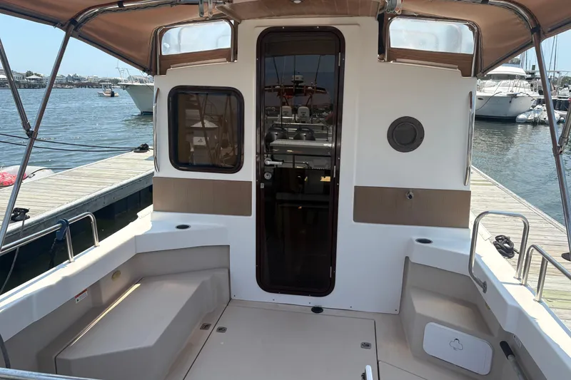 Slide: The Image of 2017 Ranger Tugs R-27 boat cockpit with canopy, docked at marina. - 9