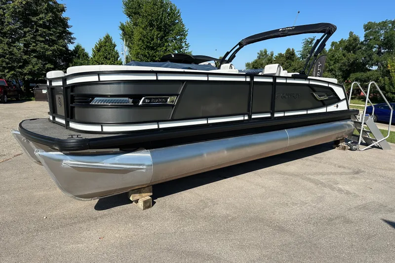 Slide: The Image of 2025 Godfrey AquaPatio 255 SB pontoon boat on display in a sunny outdoor setting. - 2