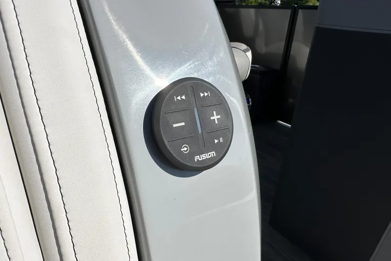 Slide: The Image of Audio control panel on 2025 Godfrey AquaPatio 255 SB boat, featuring Fusion brand buttons. - 21