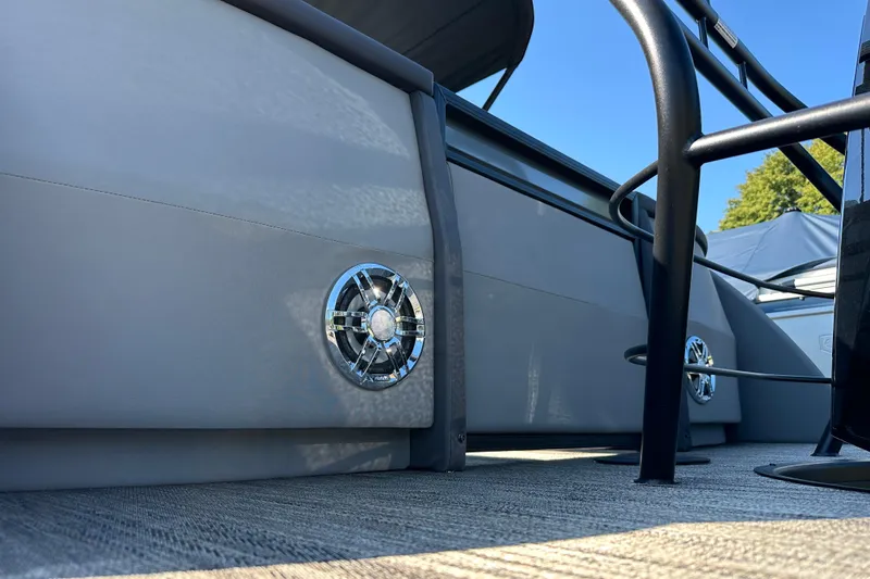 Slide: The Image of 2025 Godfrey AquaPatio 255 SB pontoon boat with sleek design and chrome speaker detail. - 5
