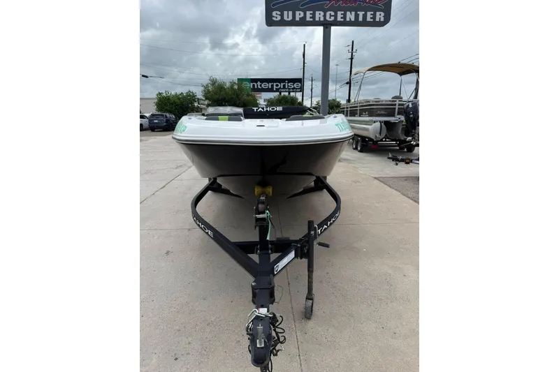 Slide: The Image of 2023 Tahoe T18 boat on trailer at dealership under cloudy sky. - 10