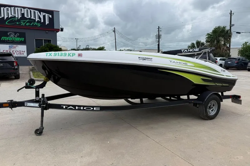 Slide: The Image of 2023 Tahoe T18 boat on trailer at dealership, featuring sleek design and vibrant accents. - 11