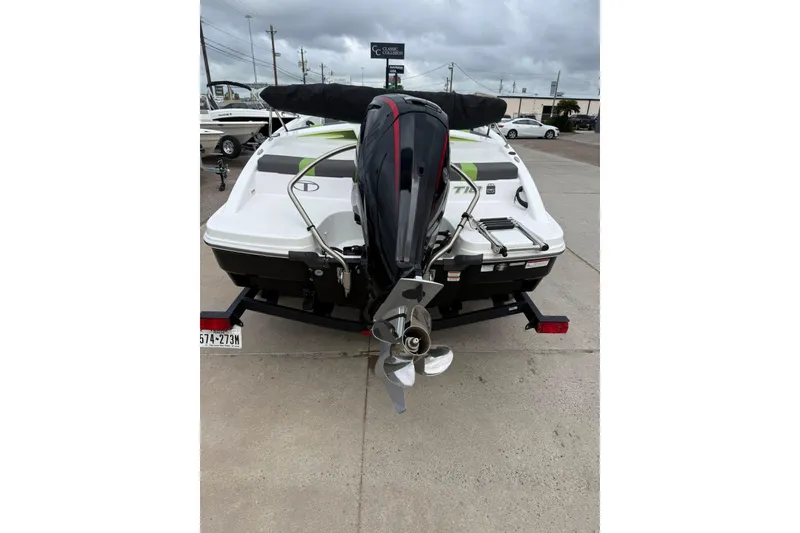 Slide: The Image of 2023 Tahoe T18 boat with outboard motor on trailer, parked outdoors. - 12