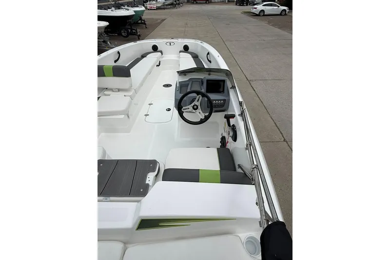 Slide: The Image of 2023 Tahoe T18 boat interior with steering wheel and seating, docked on concrete. - 4