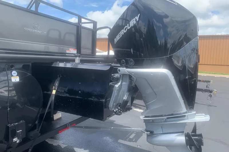 Slide: The Image of 2025 Regency 250 DL3 boat with Mercury outboard motor, parked outdoors. - 8
