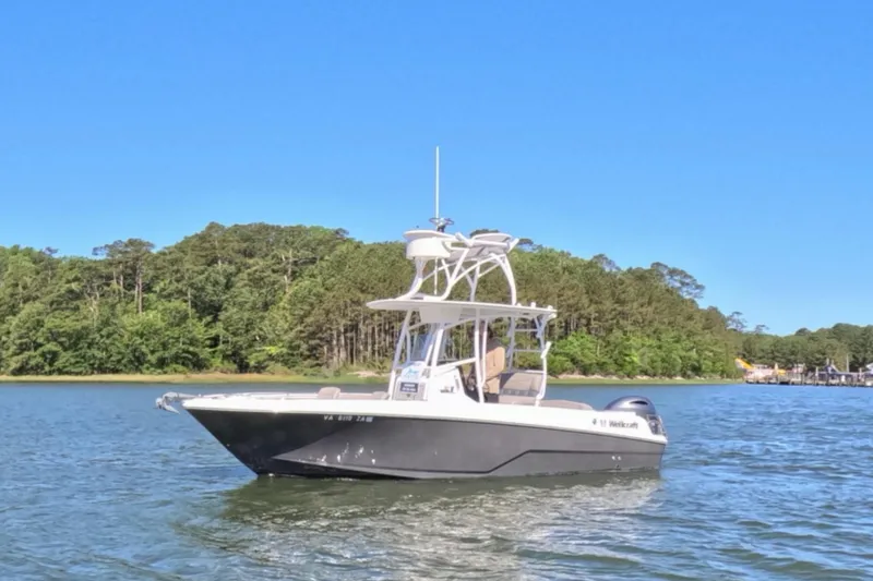 The Image of 2020 Wellcraft 222 Fisherman boat on a serene lake with lush green shoreline. - 1