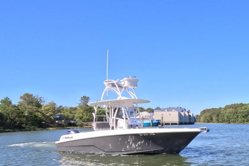 Slide: The Image of 2020 Wellcraft 222 Fisherman boat cruising on a sunny day near a wooded shoreline. - 14