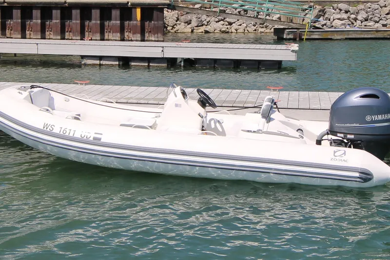 Slide: The Image of 2023 Zodiac Yachtline 490 inflatable boat docked with Yamaha outboard motor. - 11