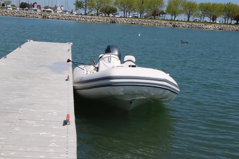 Slide: The Image of 2023 Zodiac Yachtline 490 docked on calm water near a pier. - 12