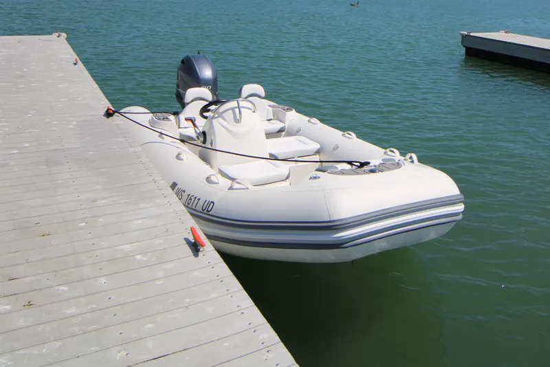 Slide: The Image of 2023 Zodiac Yachtline 490 inflatable boat docked on calm water. - 4