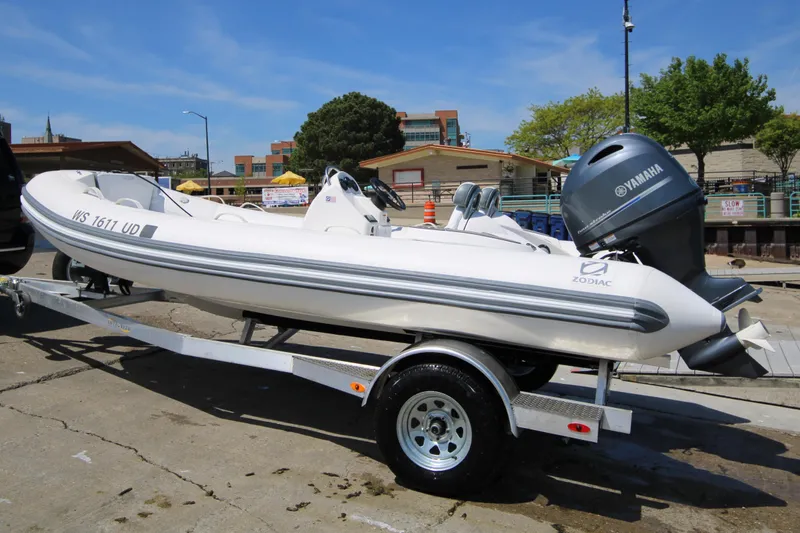 Slide: The Image of 2023 Zodiac Yachtline 490 boat on trailer with Yamaha engine, parked outdoors. - 5