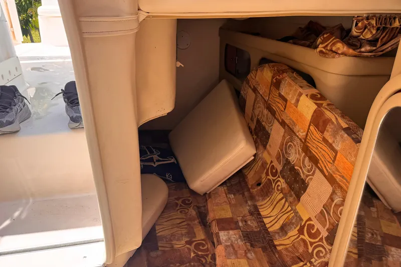 Slide: The Image of Interior of a 2004 Rinker Fiesta Vee 270 boat with patterned cushions and storage space. - 15