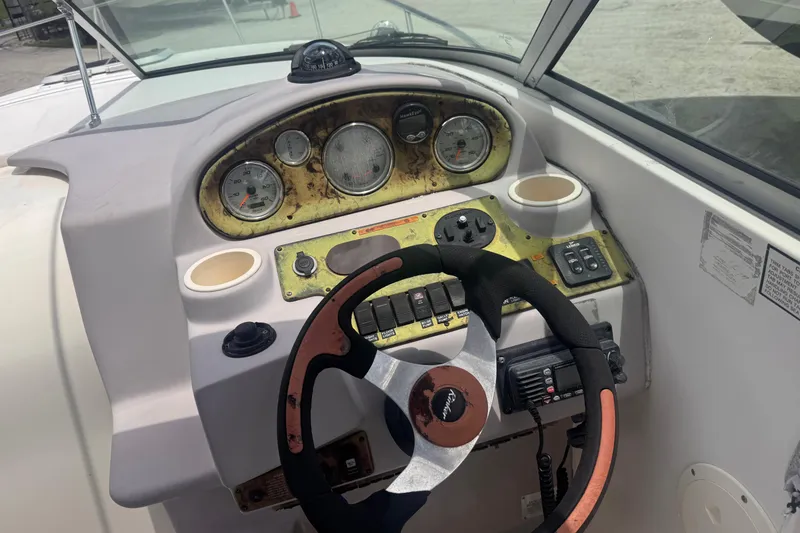 Slide: The Image of 2004 Rinker Fiesta Vee 270 boat dashboard with steering wheel and gauges. - 16