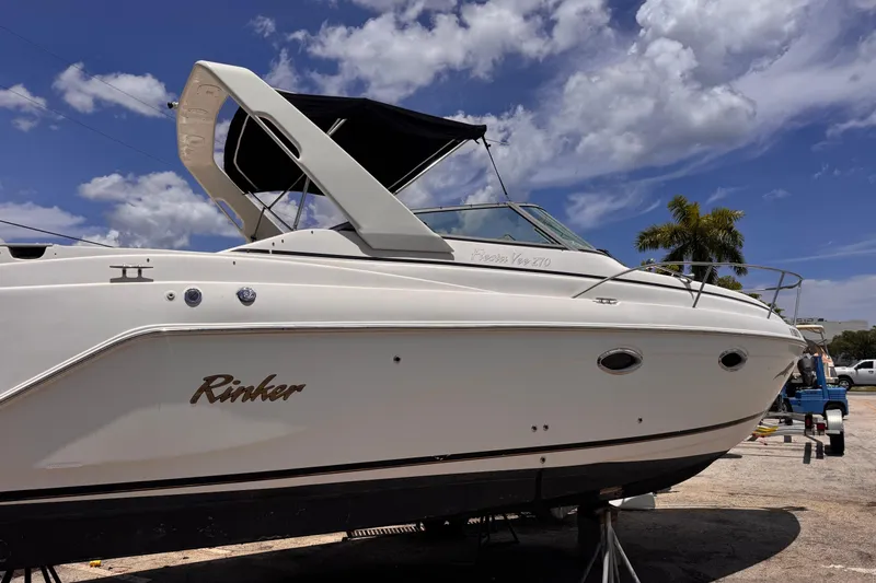 Slide: The Image of 2004 Rinker Fiesta Vee 270 boat under a clear blue sky with palm trees. - 3