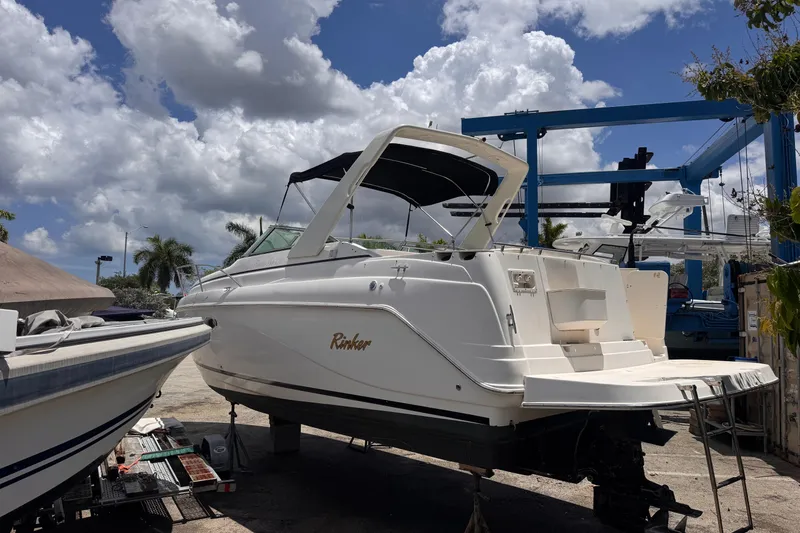 Slide: The Image of 2004 Rinker Fiesta Vee 270 boat on dry dock under a partly cloudy sky. - 5