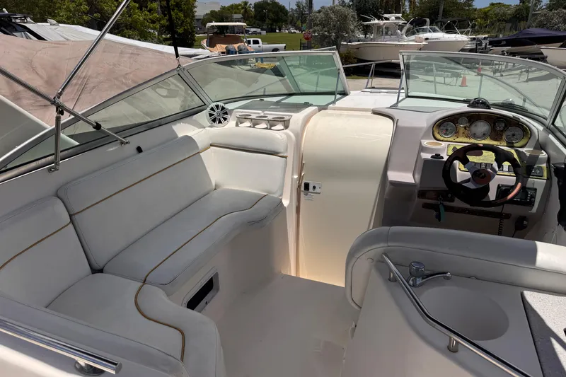 Slide: The Image of 2004 Rinker Fiesta Vee 270 boat interior with white seating and steering console. - 9