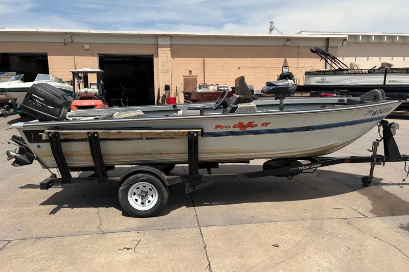 Slide: The Image of 1995 Tracker Pro Deep V-17 boat on a trailer in a parking lot. - 3