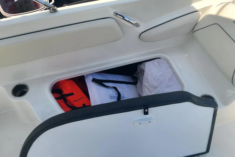 Slide: The Image of Storage compartment in 2023 Stingray 182 SC boat with life jackets and gear. - 10