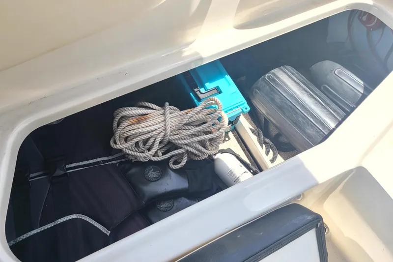 Slide: The Image of Storage compartment of 2023 Stingray 182 SC boat with rope and equipment. - 11