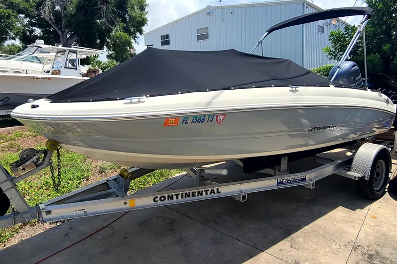 Slide: The Image of 2023 Stingray 182 SC boat on trailer with cover, parked outdoors. - 3