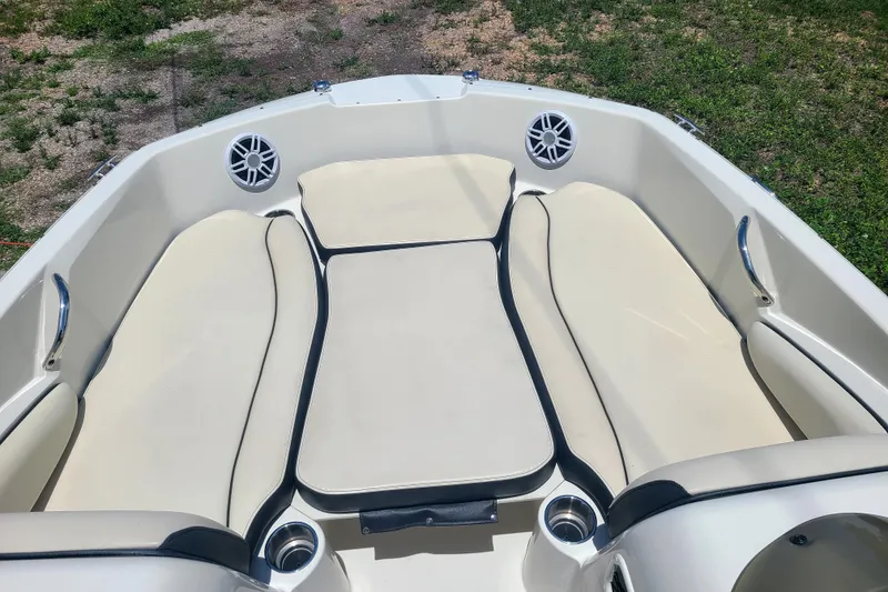 Slide: The Image of 2023 Stingray 182 SC boat interior with beige seating and cup holders. - 4
