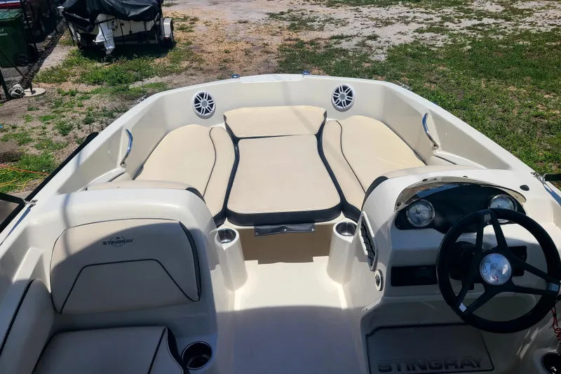 Slide: The Image of 2023 Stingray 182 SC boat interior with beige seating and steering wheel. - 5