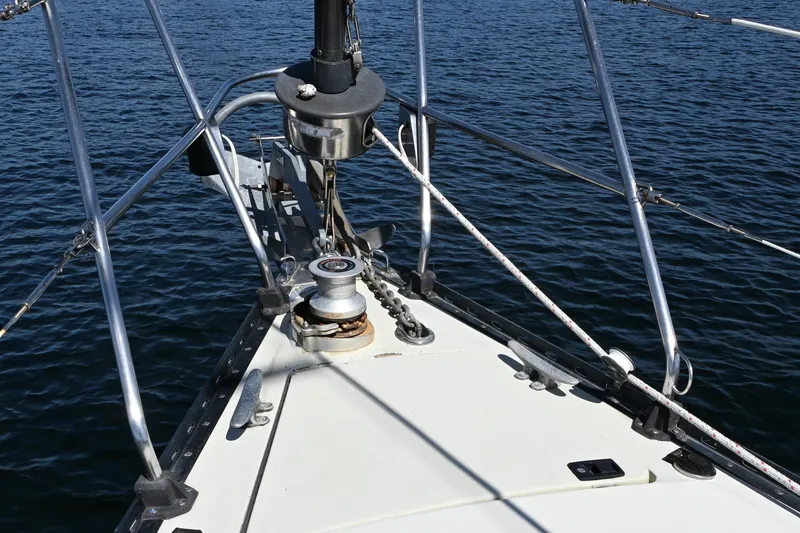 Slide: The Image of Bow of 1989 C&C 37/40+ sailboat with winch and railing, on calm water. - 32