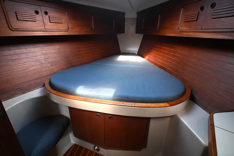 Slide: The Image of Cozy cabin interior of 1989 C&C 37/40+ sailboat with wooden accents and blue bedding. - 4